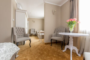 pokój z beżowymi fotelami, tulipany na stole